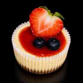 Cheesecake met aardbei, blauwe bessen en rode vruchtensaus