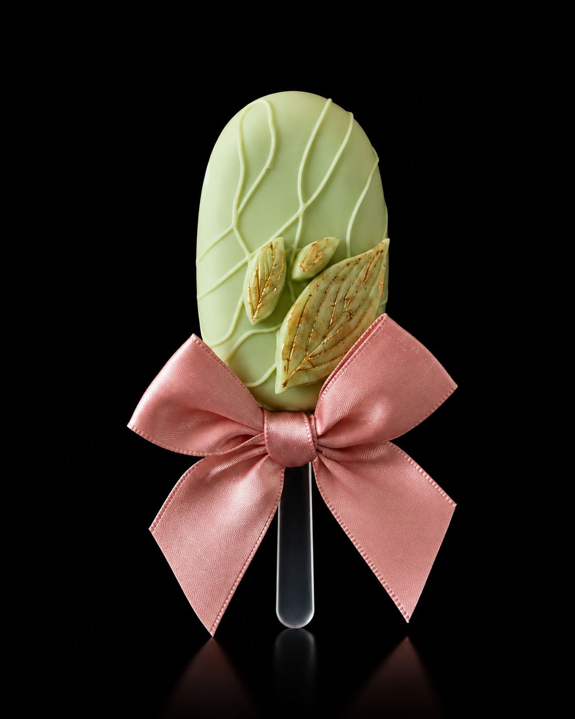 Lichtgroene cakesicle met gouden botanische details en roze strik